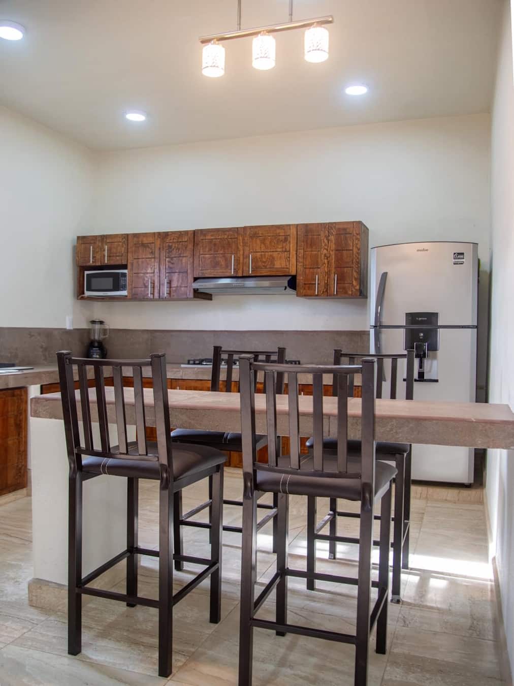 Vista de la cocina y barra desayunador del departamento en la Planta Baja de Casa Luna