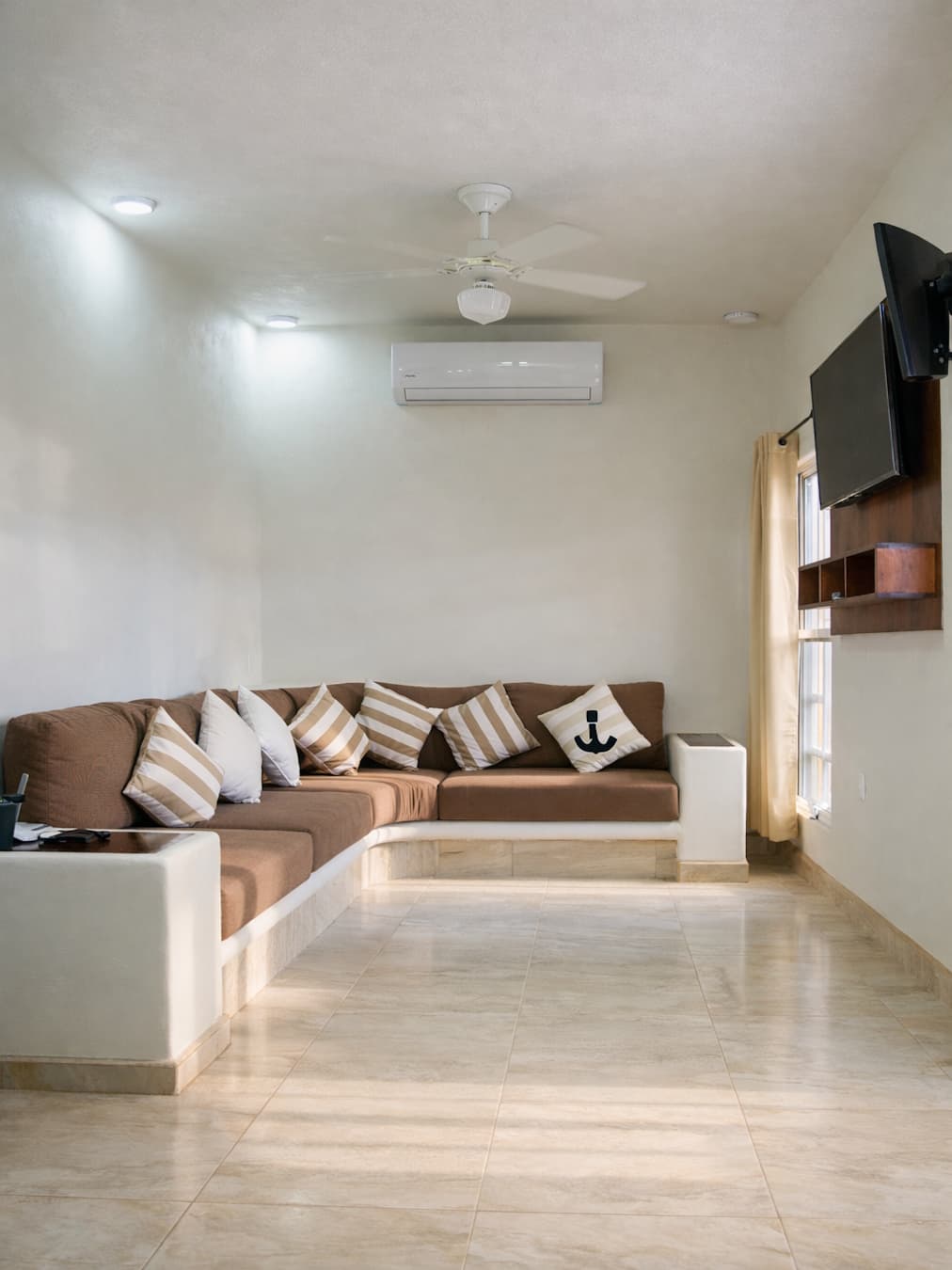 Vista de la sala y el sofá cama, aire y TV del departamento en Planta Baja de Casa Luna