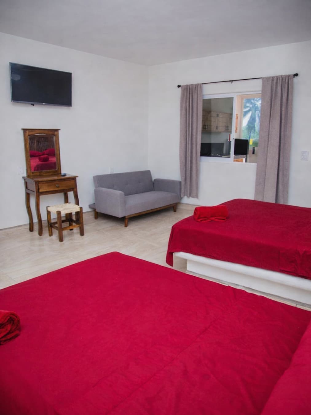 Vista de la ventana, sofá cama, el tocador y la TV del Loft 2 del segundo piso de Casa Luna