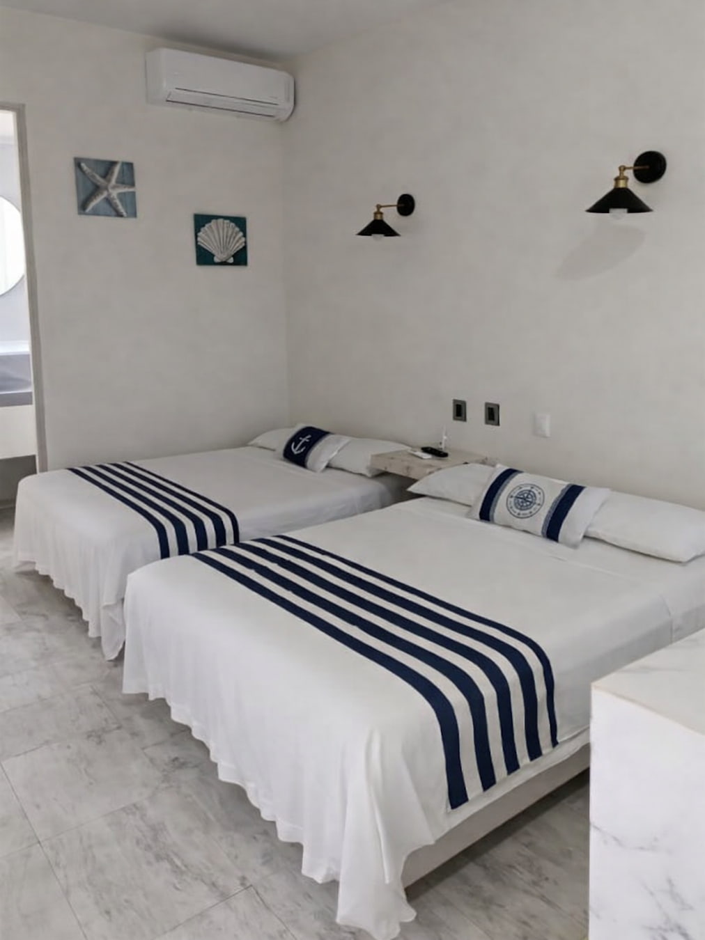 Vista de las dos camas dobles, Aire Acondicionado, decoración, lámparas y buró de la habitación Doble 1 – Casa Tania