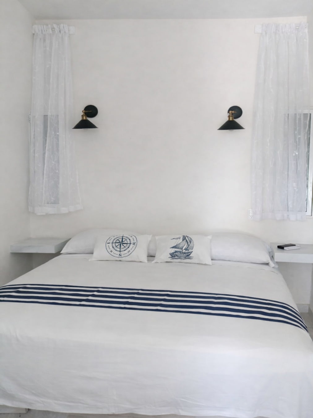Vista de la cama King, lámparas, buroes y ventanas de la habitación Doble King 2 – Casa Tania