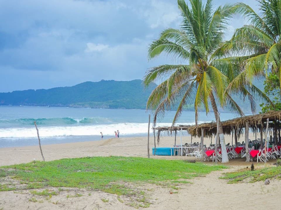 Imagen de una palapa típica y la playa virgen en Playa Larga